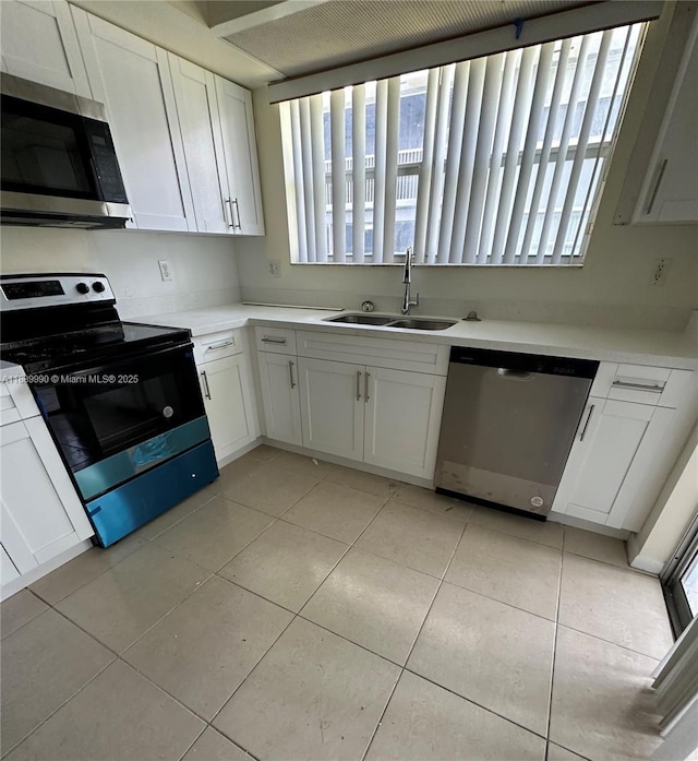 kitchen featuring sink, light tile patterned flooring, white cabinets, and appliances with stainless steel finishes