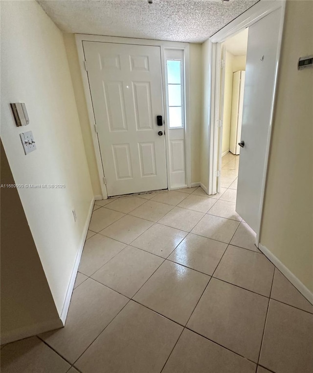 tiled foyer entrance featuring a textured ceiling