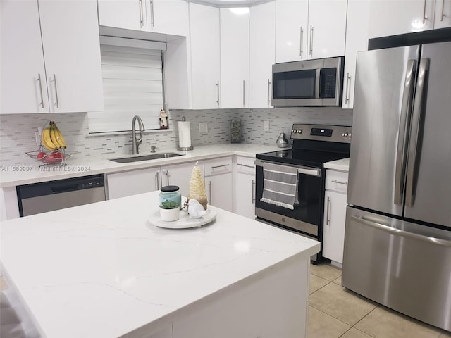 kitchen with decorative backsplash, white cabinetry, appliances with stainless steel finishes, and sink