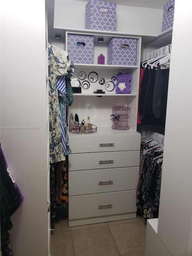 walk in closet with light tile patterned floors