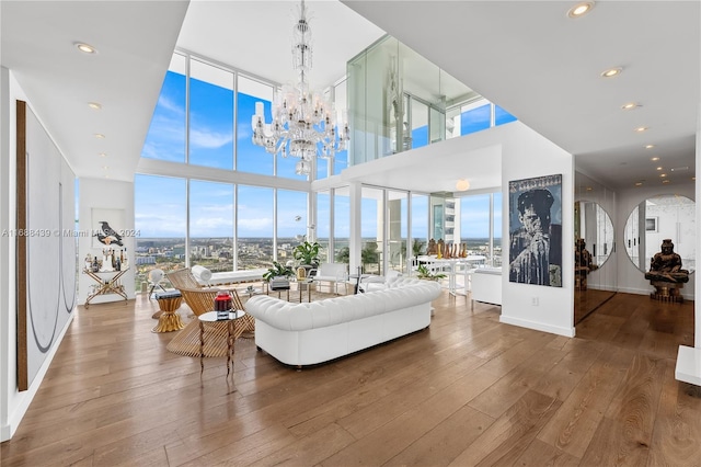 living room with hardwood / wood-style floors, a notable chandelier, and a wall of windows