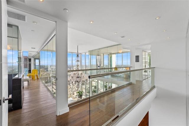 hall featuring plenty of natural light, dark wood-type flooring, and floor to ceiling windows