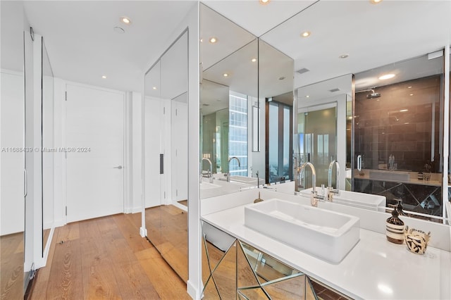 bathroom with wood-type flooring, sink, and an enclosed shower