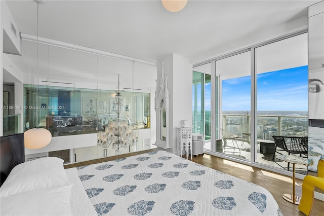 bedroom featuring access to exterior, hardwood / wood-style floors, and a wall of windows