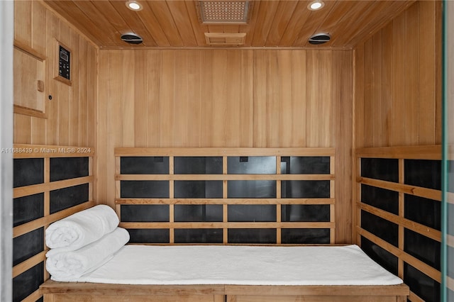 view of sauna / steam room with wooden ceiling and wood walls