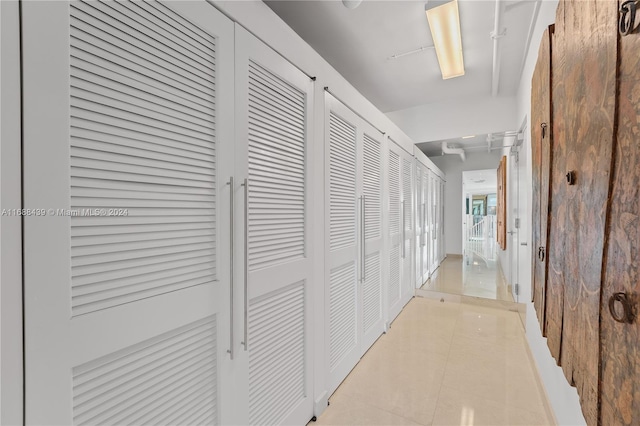 hall with light tile patterned floors