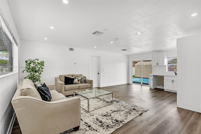 living room featuring a textured ceiling and dark hardwood / wood-style flooring