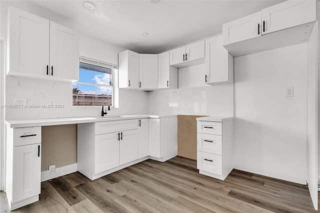 kitchen with white cabinetry, hardwood / wood-style floors, and sink