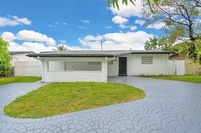 ranch-style home featuring a front lawn and a garage