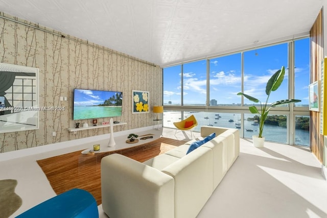 living area featuring wallpapered walls, wood finished floors, a wall of windows, and an ornate ceiling