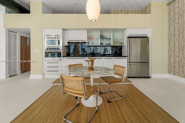 kitchen with stainless steel appliances, dark countertops, decorative backsplash, and an ornate ceiling