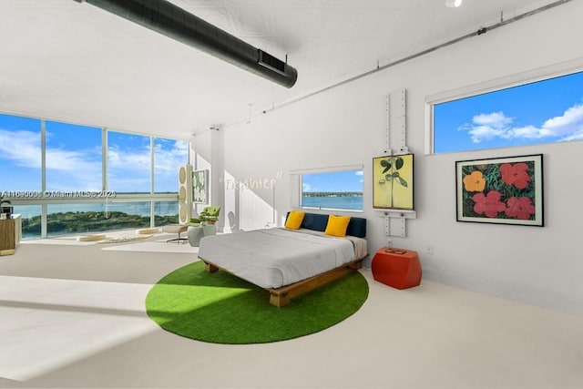 bedroom featuring a water view and baseboards