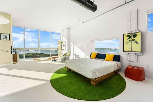 bedroom with a water view and baseboards