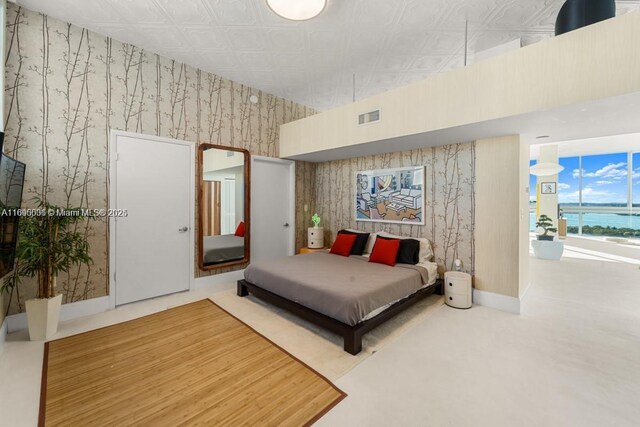 bedroom featuring a towering ceiling and a water view