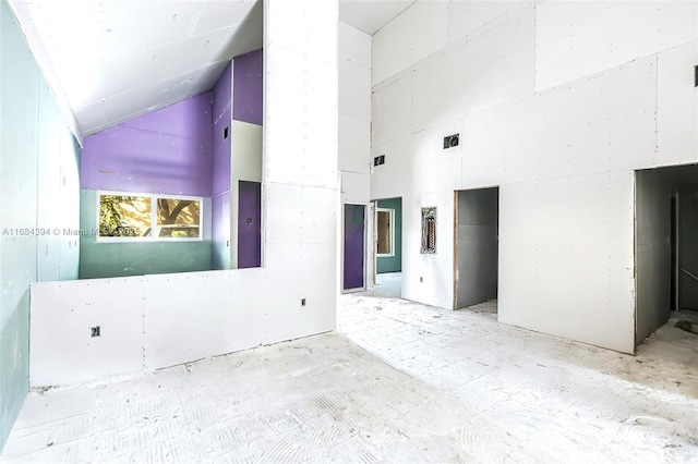 spare room featuring elevator and high vaulted ceiling