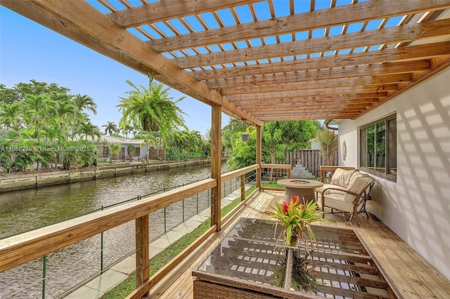 wooden terrace with an outdoor fire pit, a water view, central AC, and a pergola