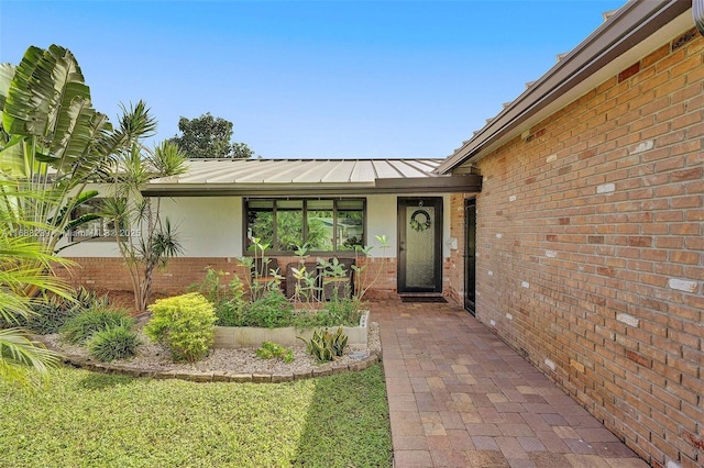 2000 NW 38th St, Oakland Park, FL 33309 - entrance to property featuring brick siding, a standing seam roof, and metal roof