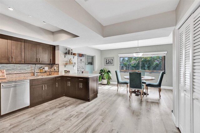 kitchen featuring dark brown cabinetry, backsplash, decorative light fixtures, light wood-type flooring, and dishwasher