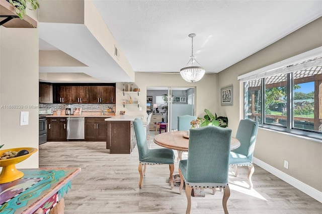 dining room with an inviting chandelier and light hardwood / wood-style flooring