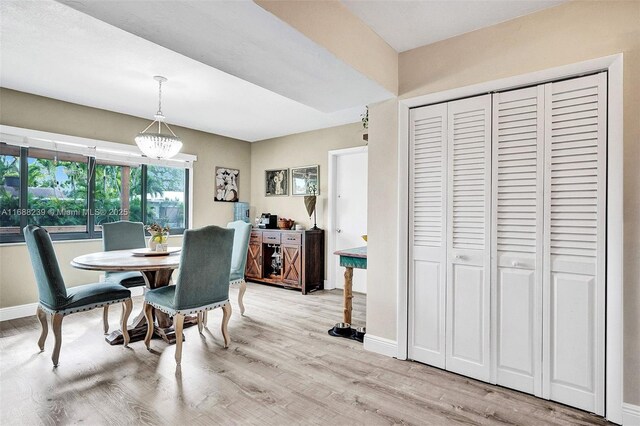 dining space featuring an inviting chandelier and light hardwood / wood-style flooring