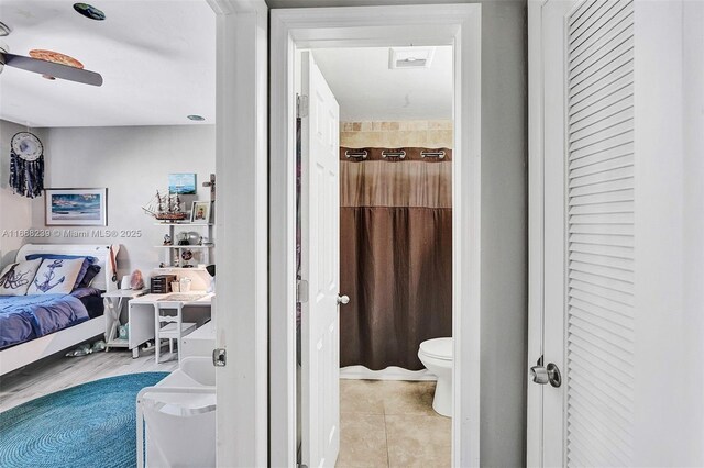 bathroom with tile patterned floors, toilet, and a shower with curtain