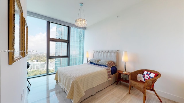 bedroom featuring a chandelier, multiple windows, and a wall of windows