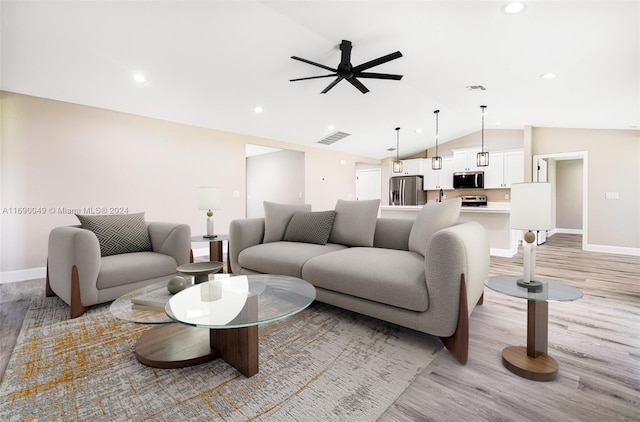 living room featuring ceiling fan, light hardwood / wood-style flooring, and lofted ceiling