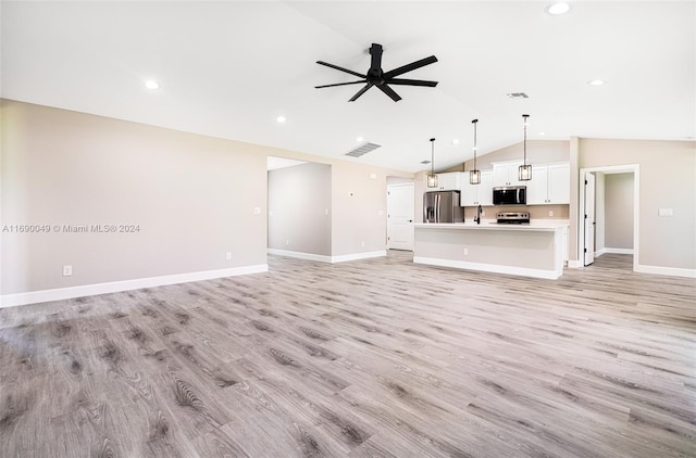 unfurnished living room with ceiling fan, sink, light hardwood / wood-style flooring, and vaulted ceiling