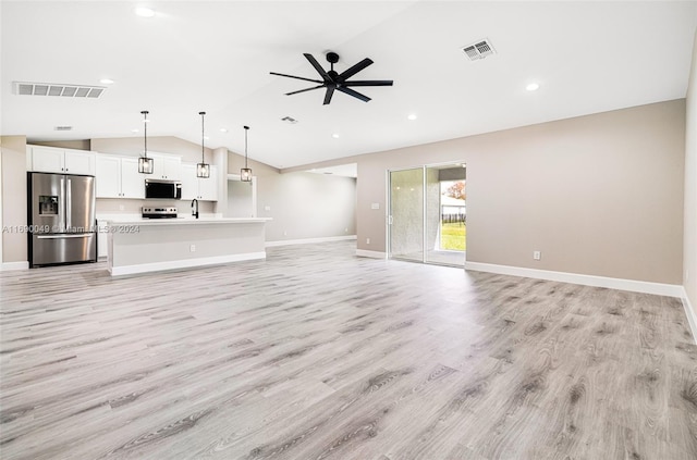 unfurnished living room with vaulted ceiling, ceiling fan, and light hardwood / wood-style flooring