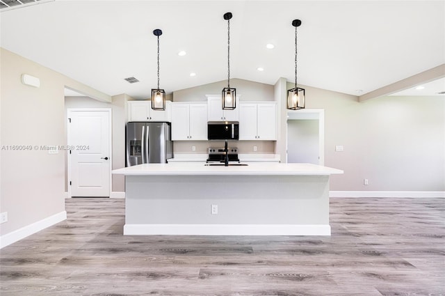 kitchen with a kitchen island with sink, stainless steel appliances, light hardwood / wood-style floors, and vaulted ceiling