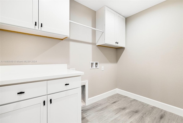 laundry room featuring hookup for a washing machine, cabinets, and light hardwood / wood-style floors