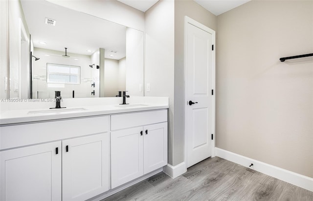 bathroom featuring wood-type flooring, vanity, and a shower with shower door