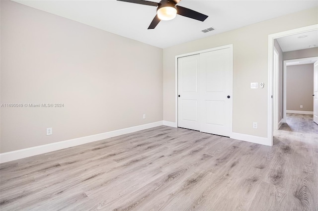 unfurnished bedroom with light hardwood / wood-style flooring, ceiling fan, and a closet