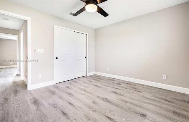 unfurnished bedroom featuring a closet, light hardwood / wood-style floors, and ceiling fan