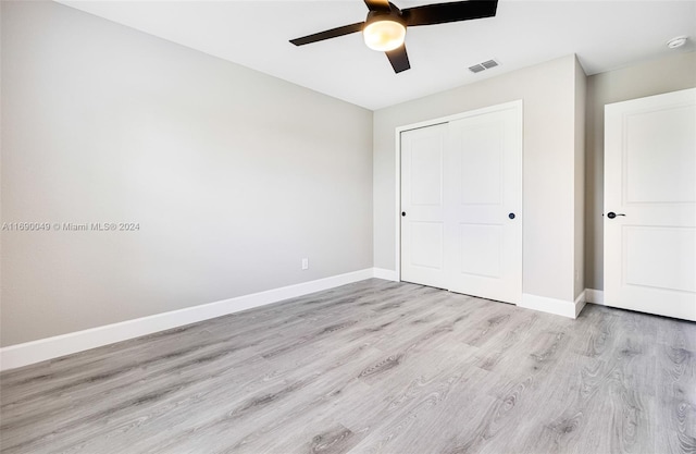 unfurnished bedroom featuring light hardwood / wood-style flooring, ceiling fan, and a closet