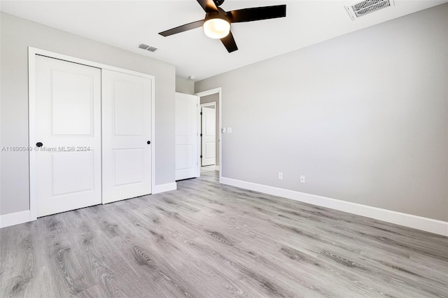 unfurnished bedroom featuring light hardwood / wood-style flooring, ceiling fan, and a closet