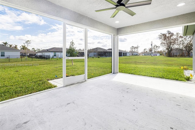 unfurnished sunroom with ceiling fan