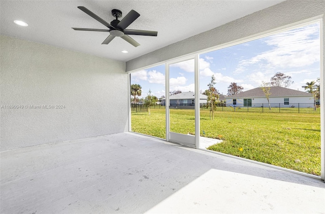 unfurnished sunroom with ceiling fan