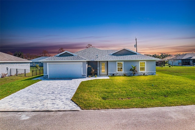 ranch-style house featuring a garage and a yard