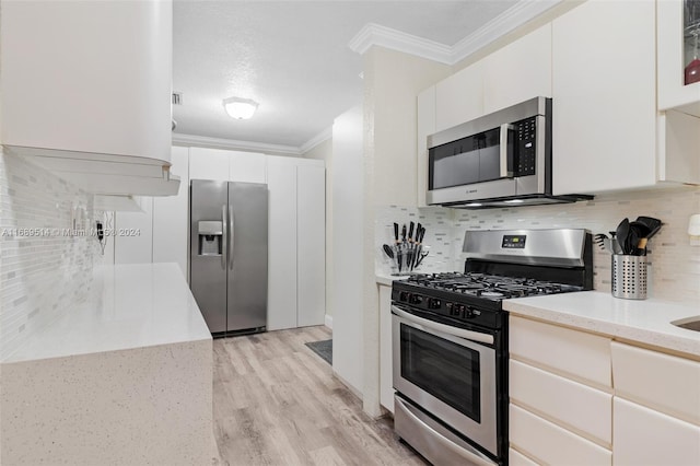 kitchen with white cabinetry, appliances with stainless steel finishes, ornamental molding, and light wood-type flooring