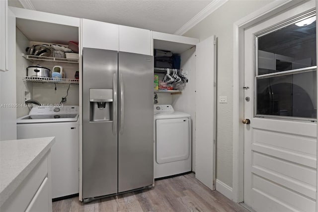 washroom featuring crown molding, light hardwood / wood-style flooring, washer / clothes dryer, and a textured ceiling