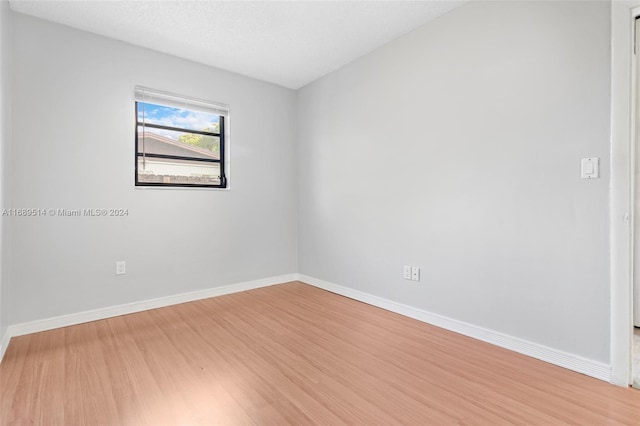 unfurnished room with hardwood / wood-style floors and a textured ceiling