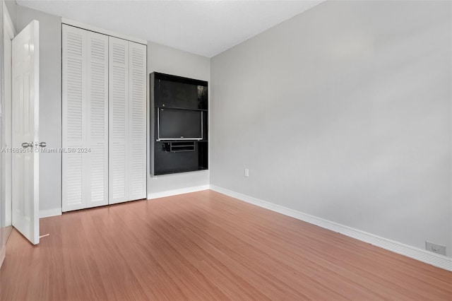 unfurnished bedroom with a closet and light hardwood / wood-style flooring