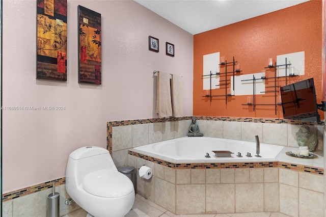 bathroom with a relaxing tiled tub, tile patterned flooring, and toilet