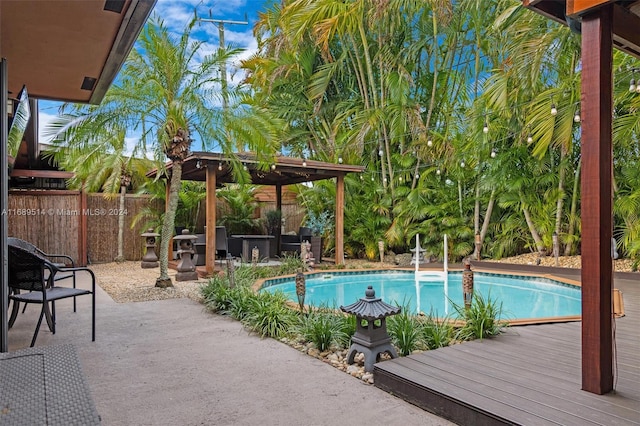 view of pool with a wooden deck and a patio area