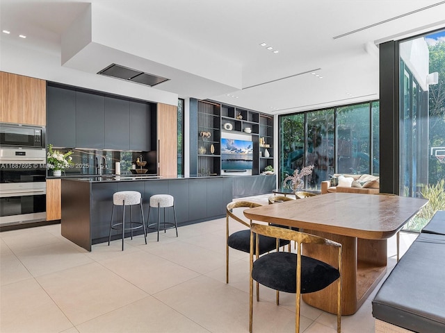 dining space with floor to ceiling windows and light tile patterned flooring