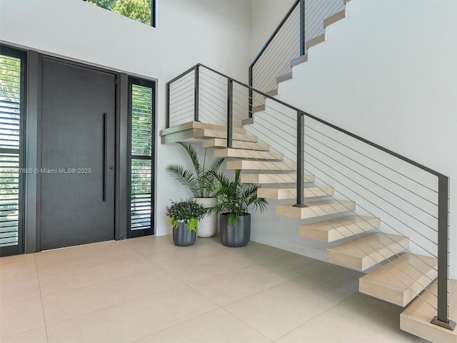 tiled foyer entrance featuring a towering ceiling