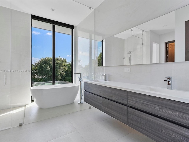 bathroom featuring vanity, independent shower and bath, tile walls, and tile patterned flooring