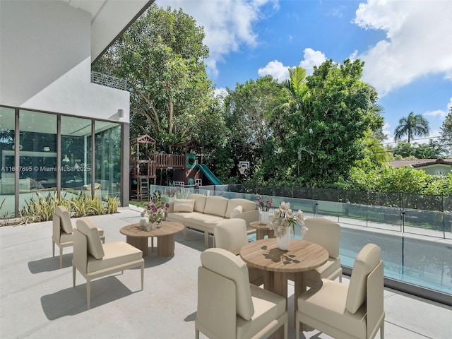 view of patio with an outdoor living space and a playground