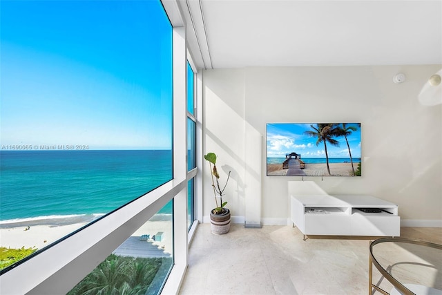 balcony featuring a view of the beach and a water view